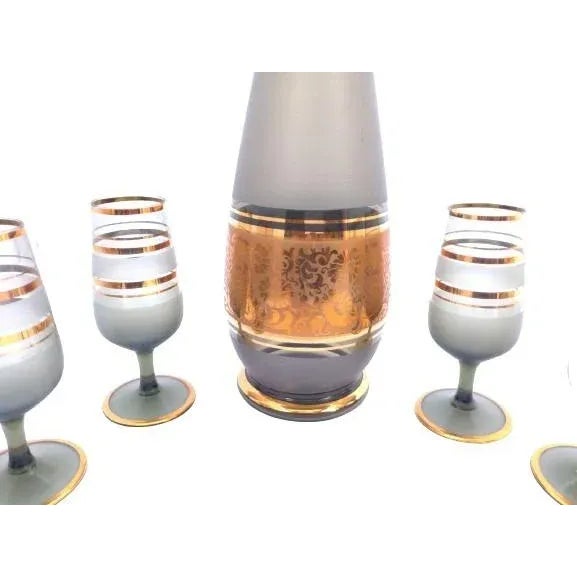 Vintage Czechoslovakian crystal decanter and six glass cup set. The set has a dark ash-green color with gold trim. It is...