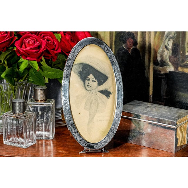 This lovely Art Nouveau sterling silver photo frame, dating to circa 1900, is a graceful expression of turn-of-the-century...