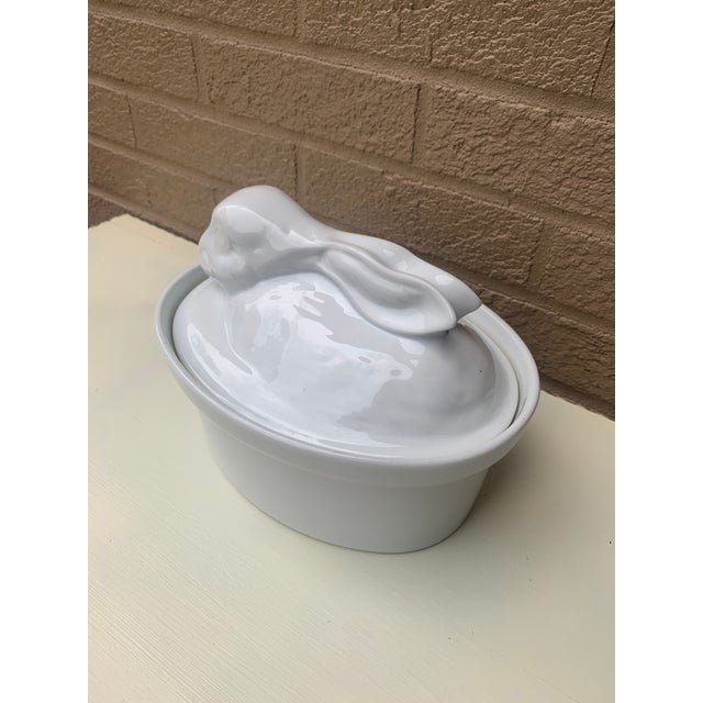 A charming white ceramic French country covered dish or casserole featuring a rabbit or hare Frane, Circa 1980s Measures:...