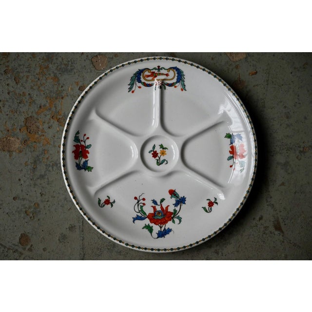 with their pretty poppy flower design on a compartmentalized background, these fondue plates, signed “Porcelaine de...