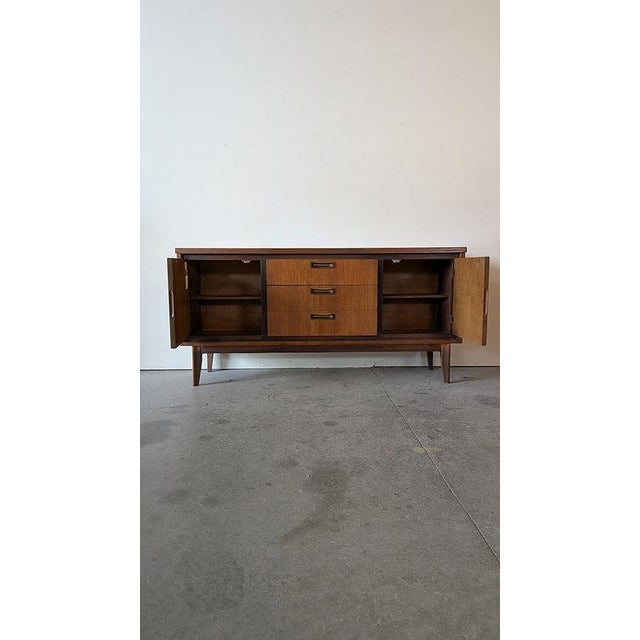 DESCRIPTION: This is a classic mid century modern console by Garrison Furniture Co., combining clean lines, warm walnut...