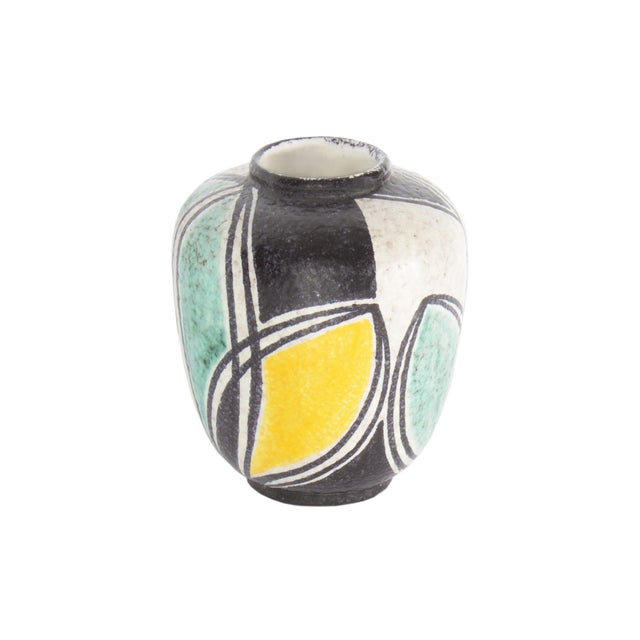 A ceramic vase produced by Wilhelm Herkenroth. Made in Germany, this rounded vase features an abstract, flower petal-like...