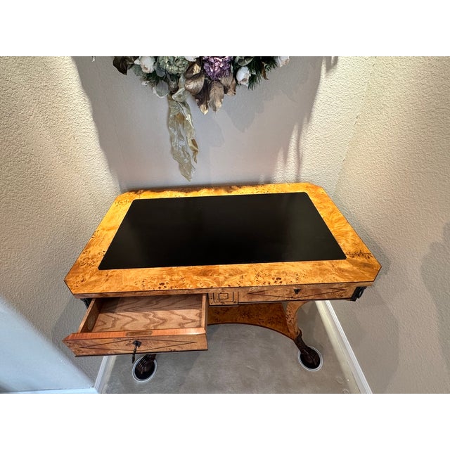 A Russian Empire burl poplar and inlaid center table, the almost rectangular top cross banded and inset with a black...