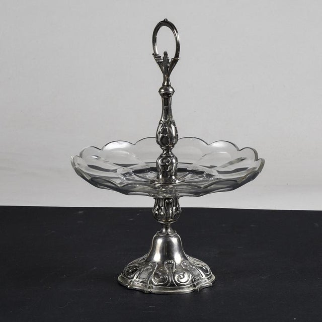 Chiseled and embossed metal centerpiece riser with decorated crystal shelf italy 20th century engraved with a probable...