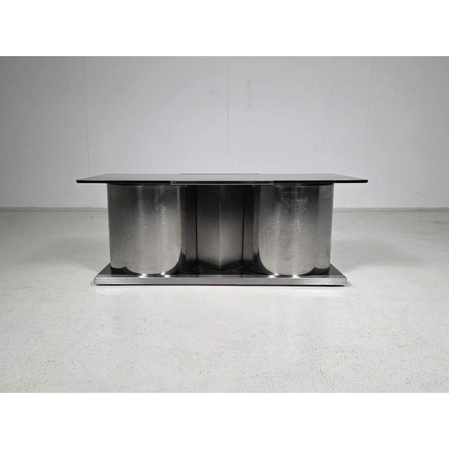Elegant dry bar by Acerbis, executed in stainless steel and rotating smoked glass, Italy, 1970s. Defined by its clean...