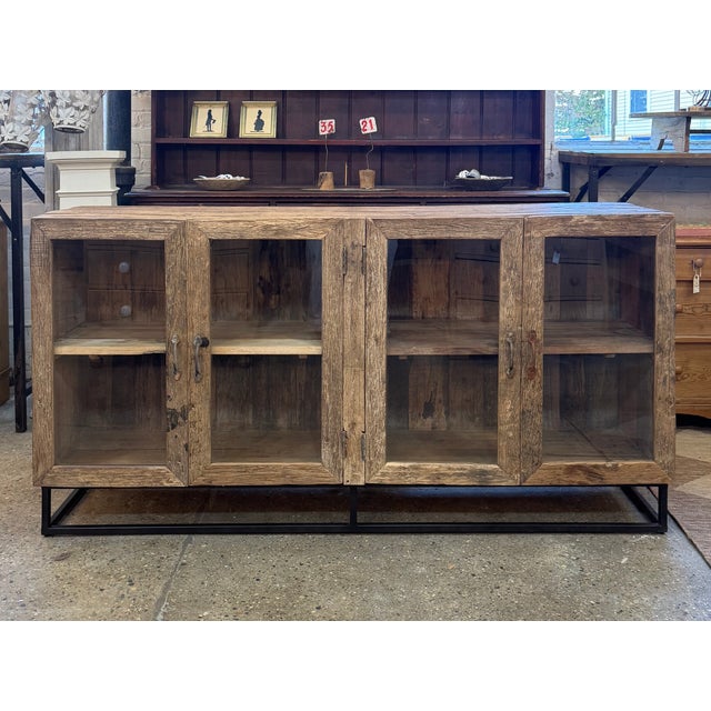 Rustic buffet built from salvaged barn wood, with deeply textured grain and a weathered, sun-faded finish. Four glass-...