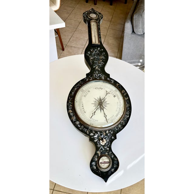 19th-century Victorian banjo-style barometer, featuring a black lacquered wood casing inlaid with mother-of-pearl. For...
