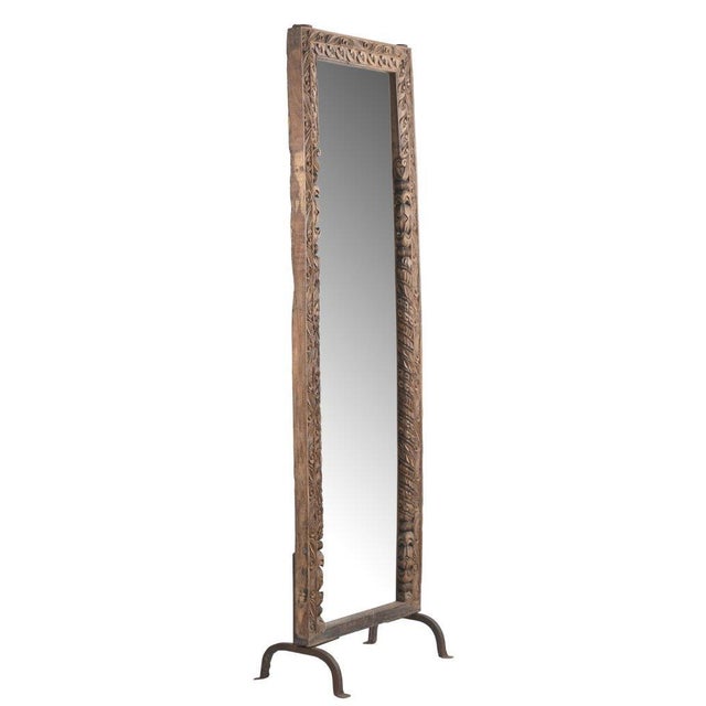 This Vintage Indian Carved Teakwood Mirror on Iron Legs is a striking floor-standing mirror crafted from solid teakwood,...