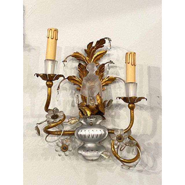 Pair of Appliques Maison Baguès, forged and golden iron structure, flowers and glass leaves, the characters are also in...