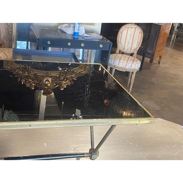 The Vintage French Maison Jansen Brass Coffee Table is a unique and elegant piece of furniture. It features a brass base...
