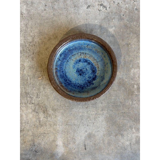 This exceptional studio pottery bowl features a striking "volcano" or fat lava style glaze effect, blending deep indigo,...
