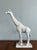 Elevate your space with this elegant and thoughtfully rendered giraffe sculpture. Cast in a textured, chalky white finish...