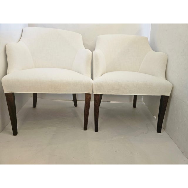 Beautiful tailored sophisticated 1940s club lounge chairs newly upholstered in white linen. Elegant wooden tapered legs.