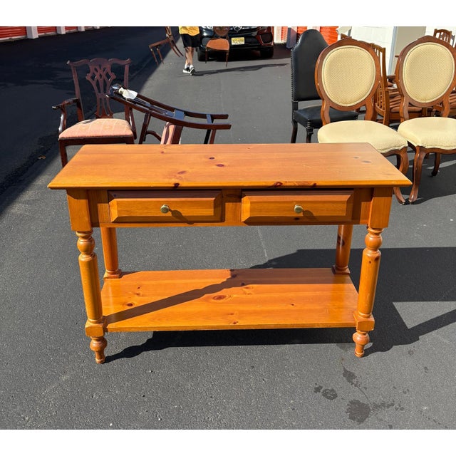 This charming knotty pine side table by Open Home features classic turned legs, warm honey-toned wood, and two functional...