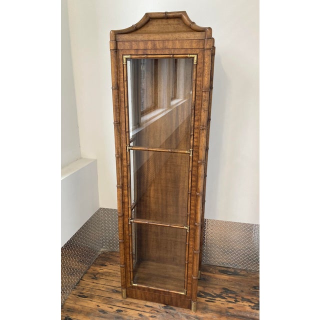 Chinoiserie-style curio cabinet by Weiman Furniture features fruit wood effect finish with brass details, full length...