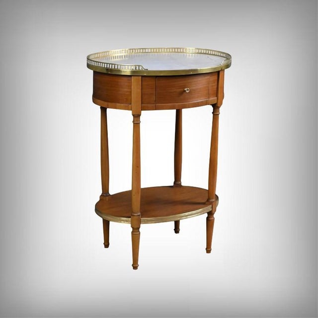 This small oval coffee table in mahogany and mahogany veneer, crafted in the refined Louis XVI style, captivates with its...