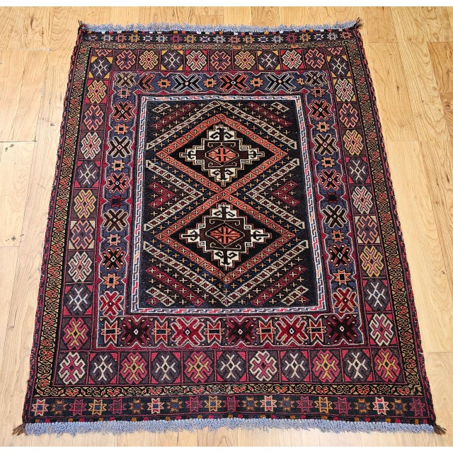 Vintage Afghan Baluch Tribal Area Rug, meticulously hand-knotted in the mid-1900s. Woven by the nomadic Baluch tribes of...