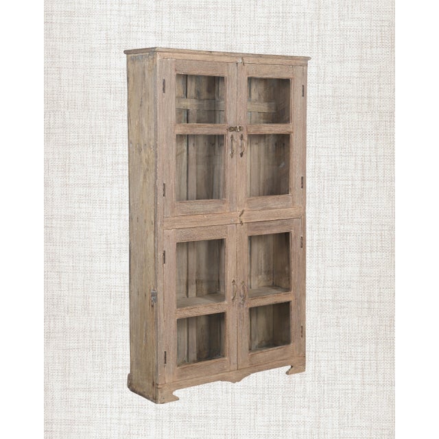 Bleached by sun and time to a pale, silvery tone, this antique Indian Armoire is calm and architectural. Four glass panels...