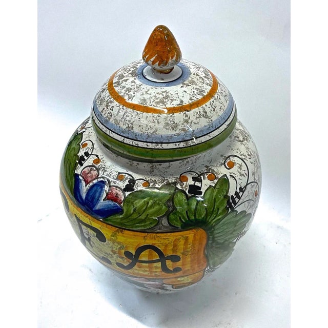 Vintage Italian Deruta style lidded tea canister. Hand Painted Floral and leaf designs. Marked "Tea" on the front, and...