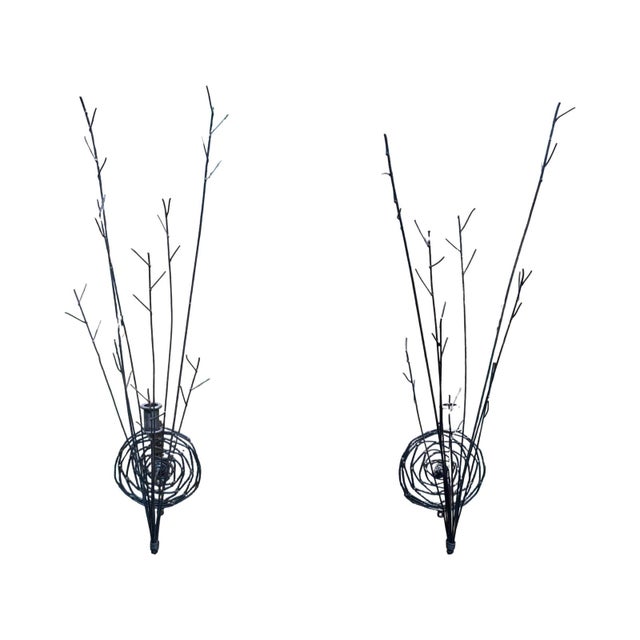 Rustic black iron candle wall sconces. Thin branchlike metal with scrolling round metal backplate.