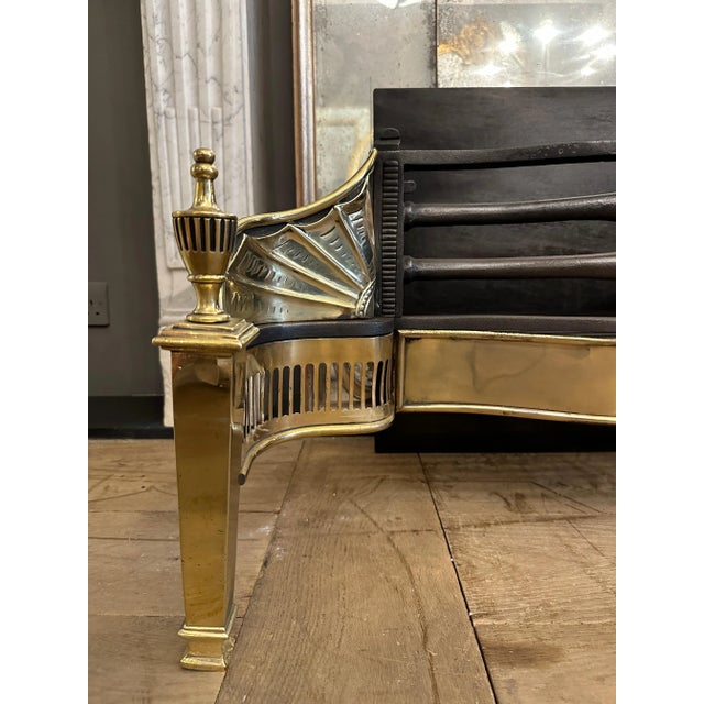 A large and unusual antique English fire grate from the last quarter of the 19th century. The brass serpentine shaped...