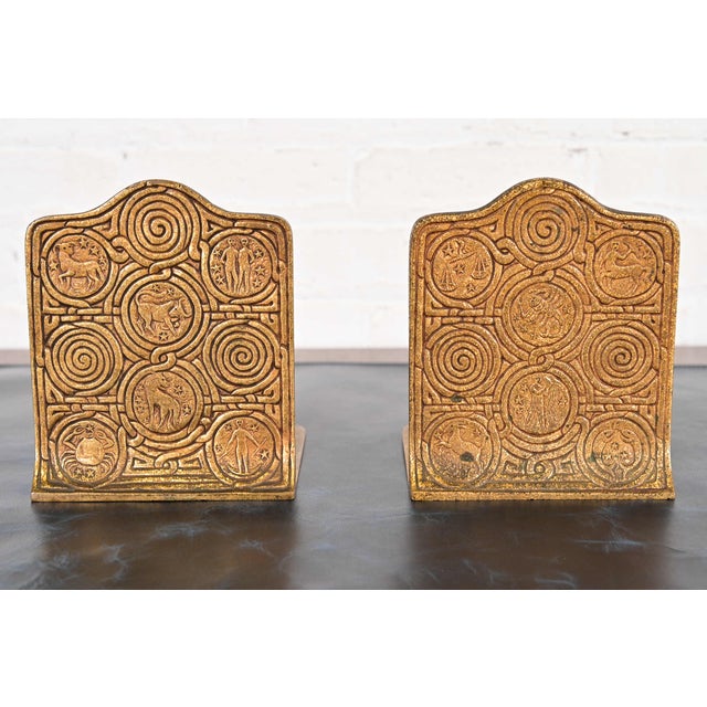 A gorgeous pair of Arts & Crafts or Art Deco period gilt bronze bookends featuring Zodiac designs By Tiffany Studios...