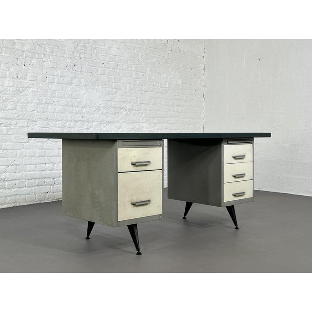 A 1950s desk with an all-metal frame and a dark green resin top. Designed by Behin, the French specialist in school and...