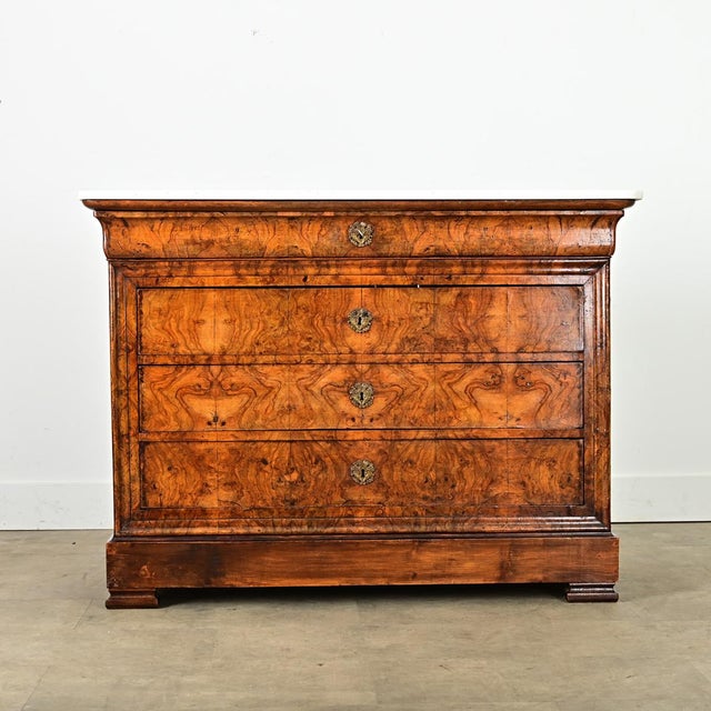 This Louis Philippe commode from France, 19th century, has mesmerizing burled, bookmatched walnut drawer fronts with dense...