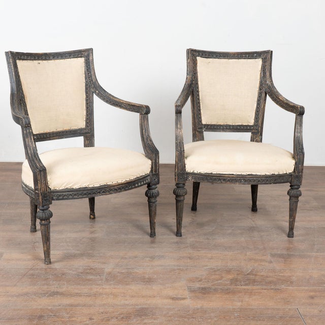 Pair of 19th century Swedish Gustavian armchairs crafted in pine. The chairs feature carved egg and dart detailing along...