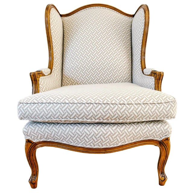 Beautiful pair of French Provincial or Louis XV style wingback armchairs with a carved solid walnut frame with a warm,...