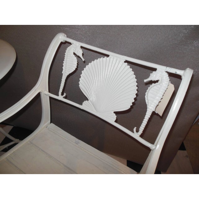 A three-piece cast iron Bistro set, the chairs are cast iron and maintain their original wooden slatted seats, the table...