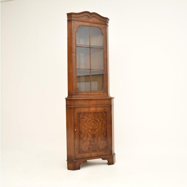 A smart and useful antique Georgian style burr walnut corner cabinet, made in England and dating from around the 1950’s...