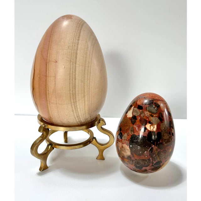 A sculptural pair of oversized vintage polished stone eggs, each displaying distinctive natural veining and earthy mineral...