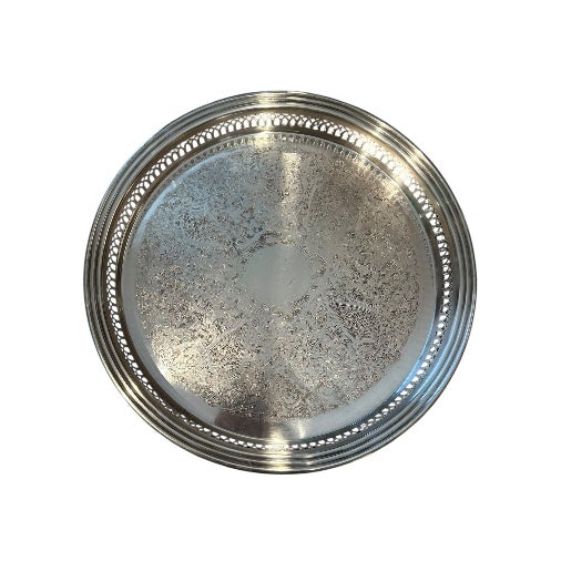 Elegant and classic, this vintage silver-plated serving tray features engraved floral and scroll motifs and a lovely...