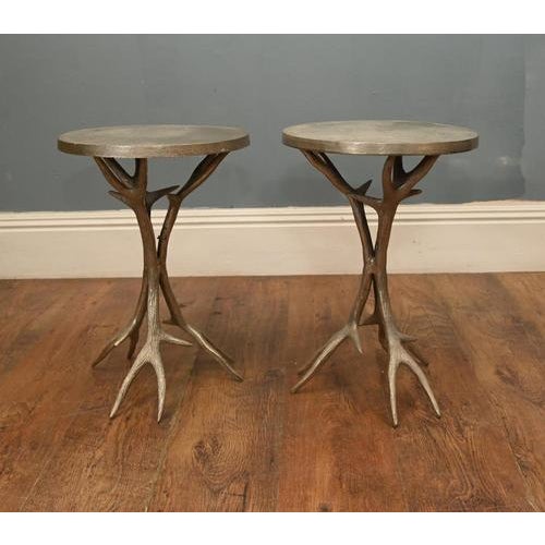 A striking pair of decorative side tables featuring sculptural bases modelled as naturalistic stag antlers. The bases are...