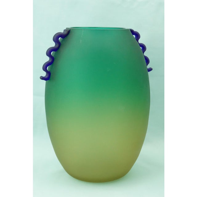 A stunning Murano glass vase, green at the rim that slowly fades to yellow toward the base, with small handles made from...