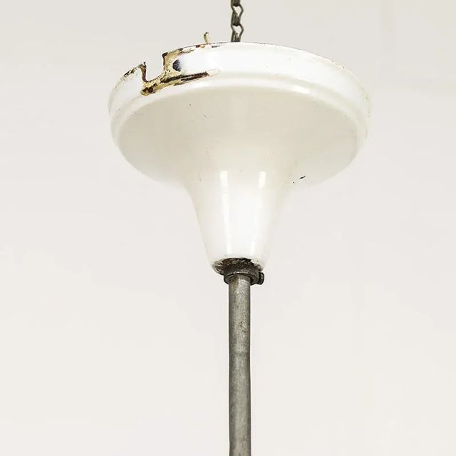 Beautiful Art Deco pendant lamp with pink glass and unique fixture with enamel shade holder and ceiling cap. The lamp has...
