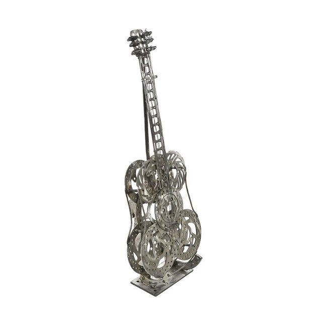 Decorative guitar made by hand with car parts, nuts, bolts and metal ropes. This piece is designed in the style of the...