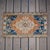 This charming vintage accent rug features a striking central medallion surrounded by earthy terracotta and deep navy blue...