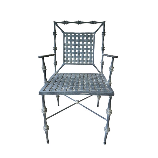 A gorgeous, pair of faux bamboo armchairs by Phyllis Morris. Each features stylized cast faux bamboo and basket woven...