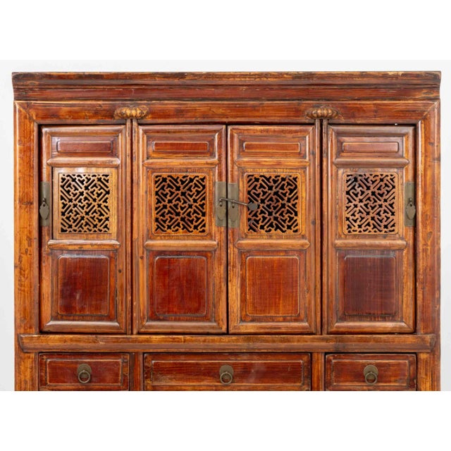 Chinese Carved Elm Wood Cabinet, early 20th century, the upper level with with pierced doors, above three central drawers,...