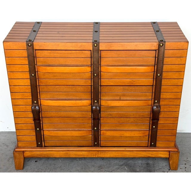 French Moderne Style Leather-Strapped Six-Drawer Chest in the Manner of Jacques Adnet This French moderne-style leather-...