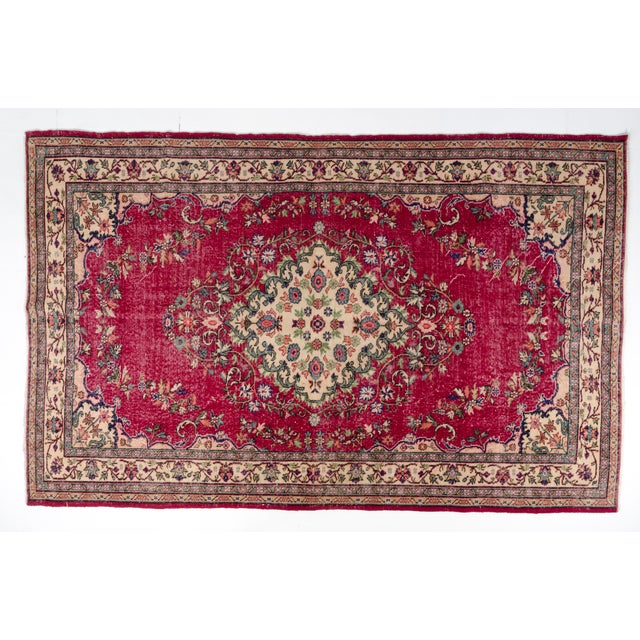 This is a vintage Turkish Oushak rug from the Mid 20th Century. The piece was hand-knotted.