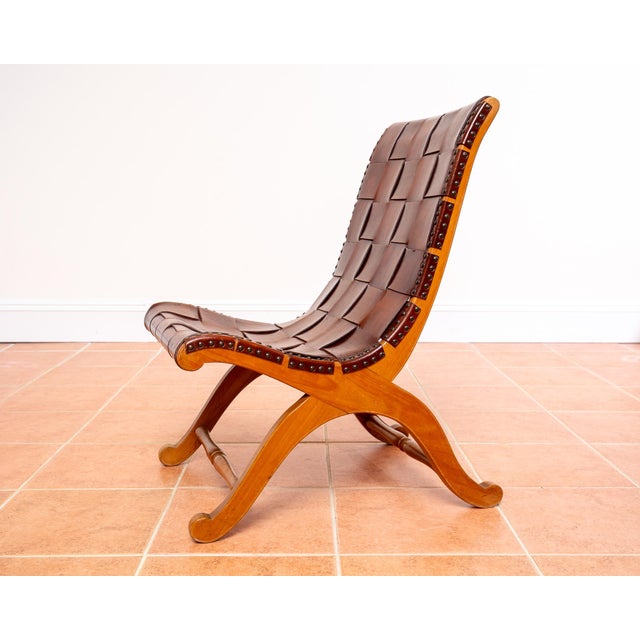 A stunning and rare beech wood and cigar leather strap slipper chair in lovely condition. Attributed to pierre lottier for...