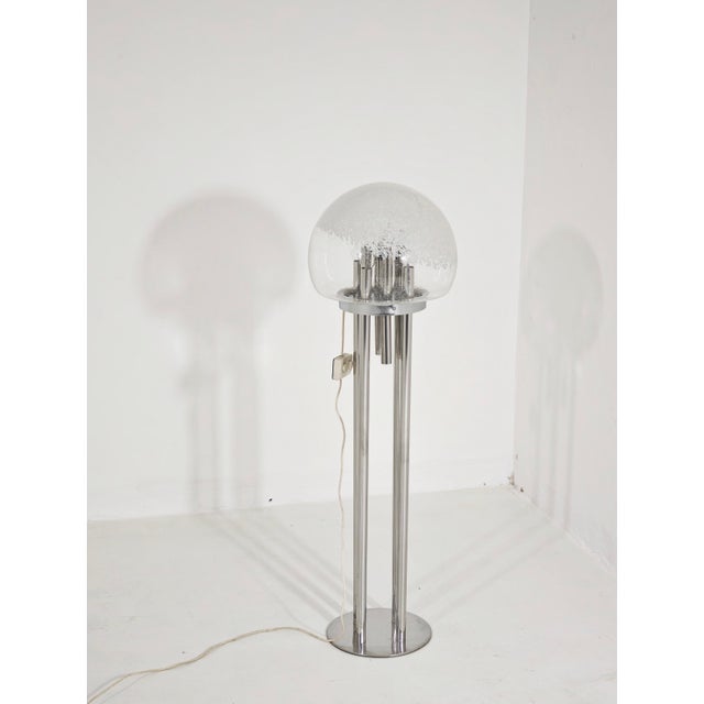 A space age floor lamp from the 1970s, featuring a large murano glass globe diffuser, often associated with the designs of...