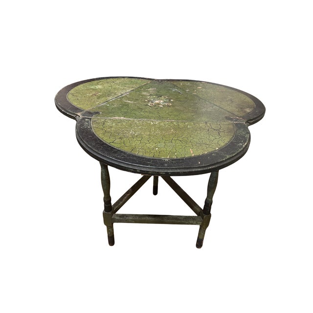 An adorable little drop leaf "clover" table in original paint. Three leafs in total in green and black paint with a center...