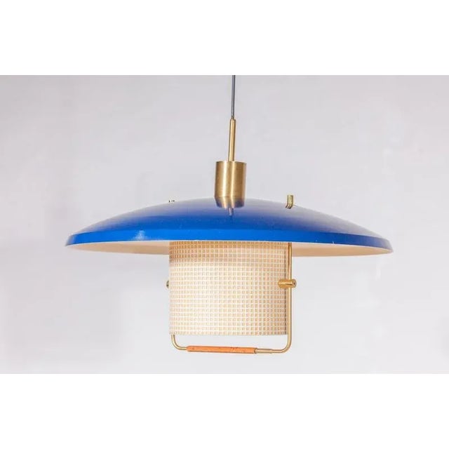 A very rare pendant in enameled metal, deep blue metal and custom brass ceiling plate, solid brass pulley. The height can...