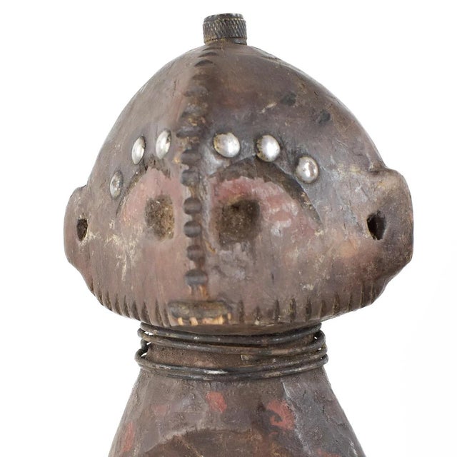 This carving was hand-crafted by the Songola people of Congo. It has an intricate skirt design and is adorned with metal....