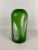 Vintage round bullet shaped green art glass vase with swirls of white and transparent openings.