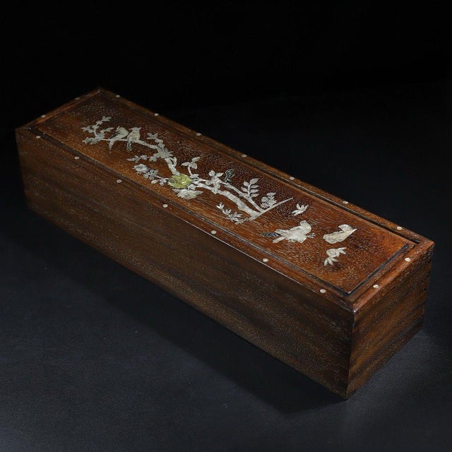 This is a beautifully crafted rectangular wooden box featuring a sliding lid adorned with intricate mother-of-pearl...